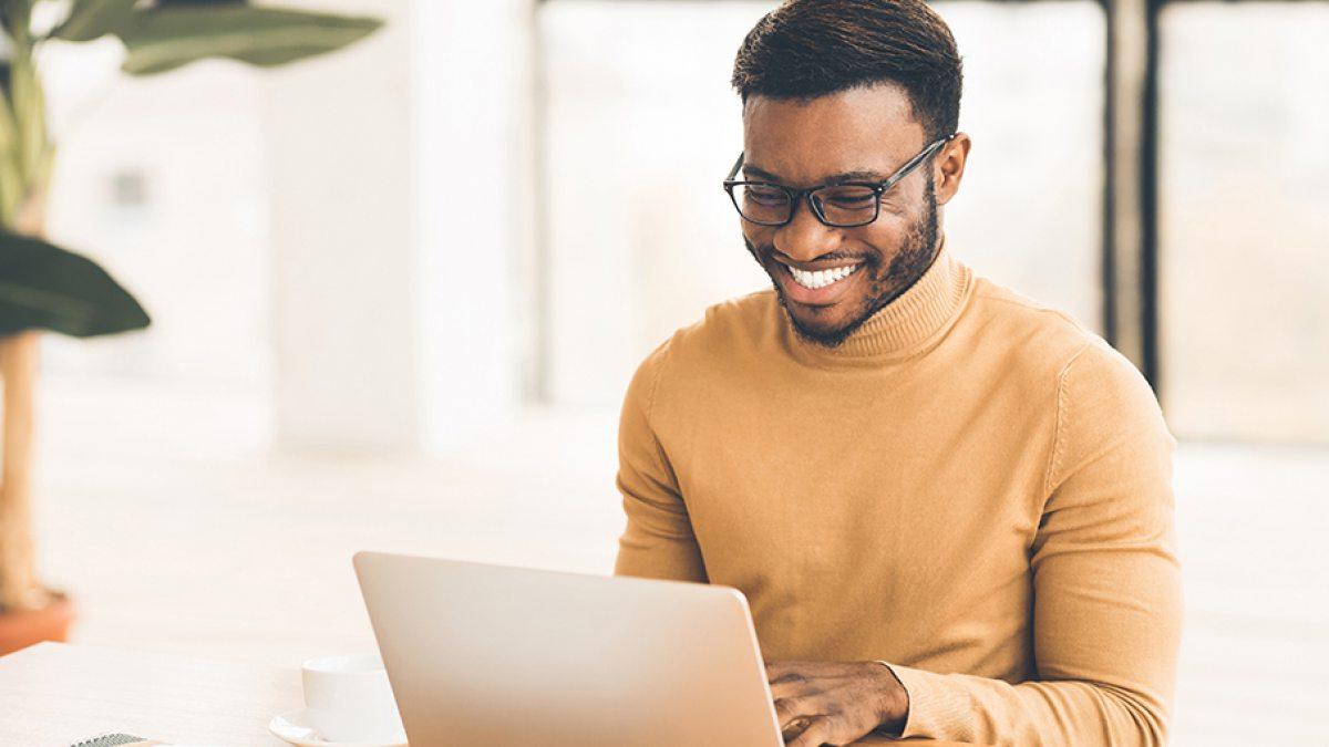 A man types on a laptop.